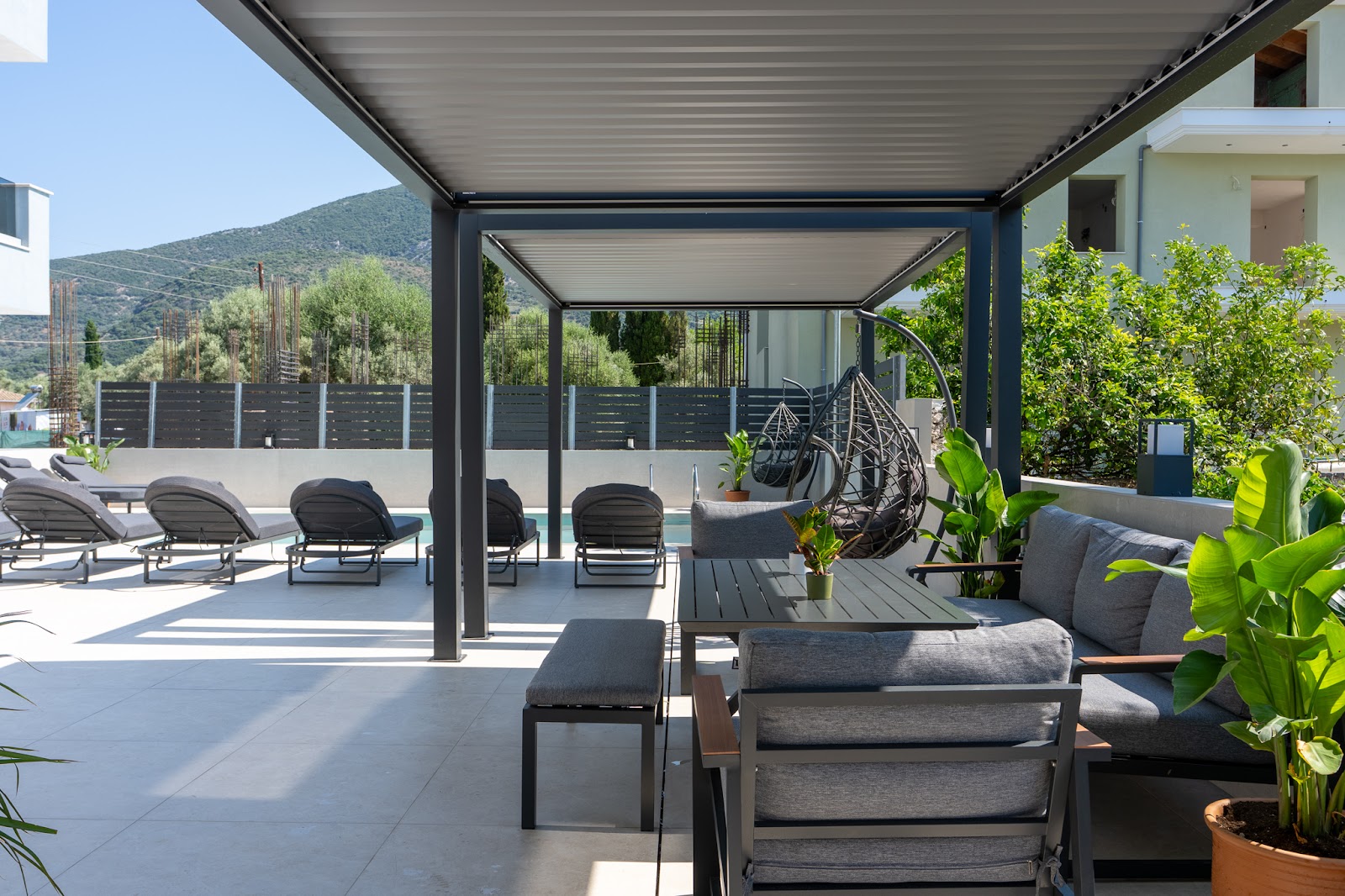 Terasă umbrită cu șezlonguri lângă piscină, cazare în Lefkada